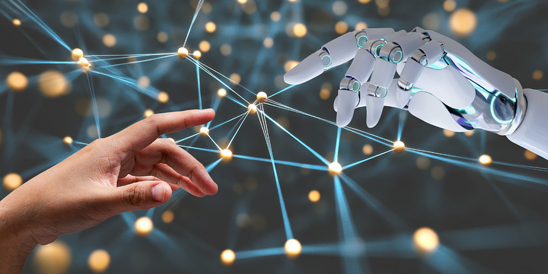 a human hand and robot hand reaching out to each other